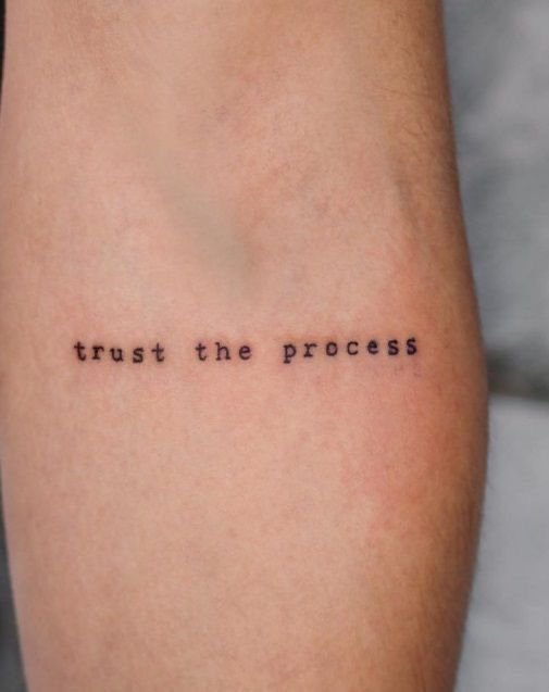 Frase 'trust the process' tatuada en el antebrazo