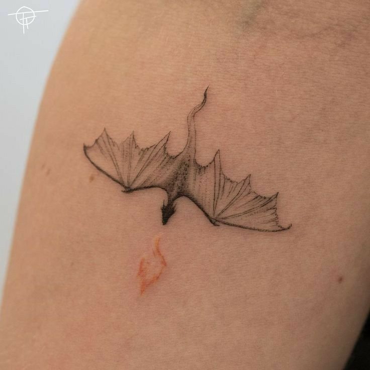 Dragón de línea fina tatuado en el brazo