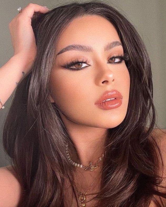Sombra en tonos malva con labios brillantes y ondas sueltas