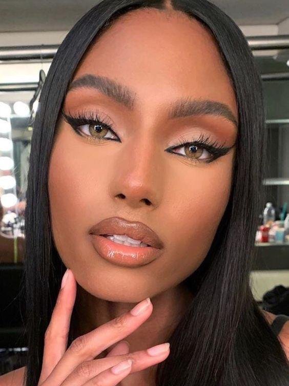 Ojo ahumado con pestañas postizas y labios nude brillantes