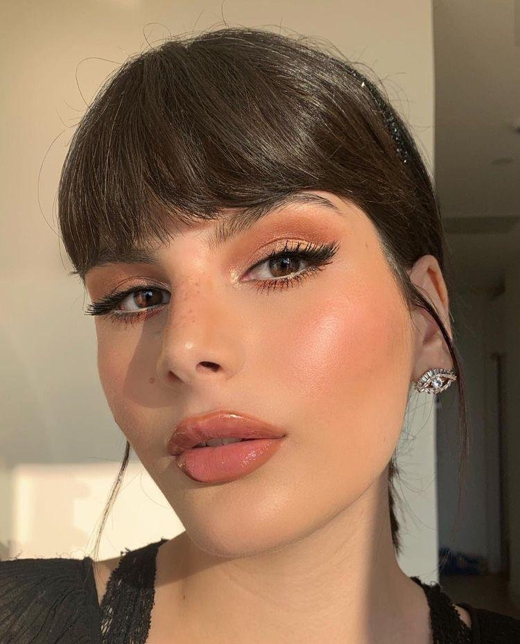 Delineado con rabillo y flequillo recto con labios glossy