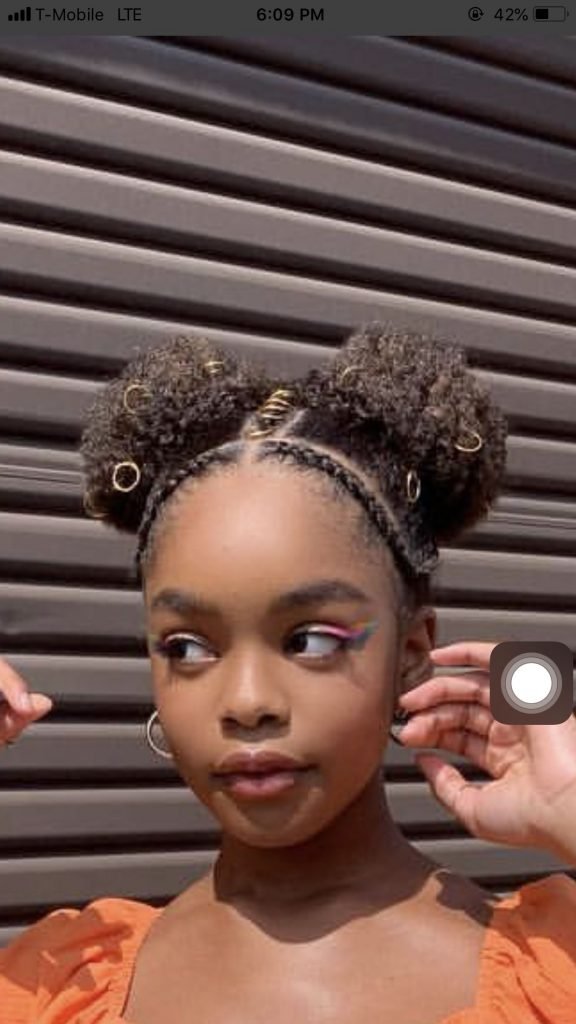 Niña con dos chongos afro y broches de colores
