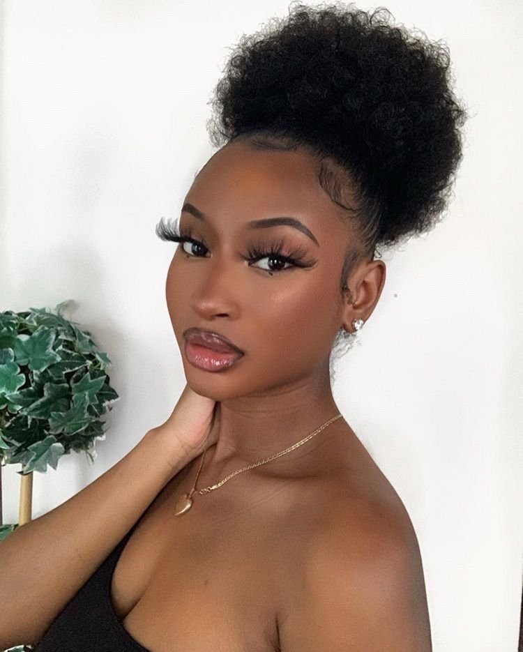 Chongo afro alto y voluminoso con el rostro despejado
