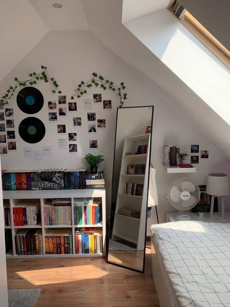 Pared con fotos, discos y estanterías junto a un espejo de pie