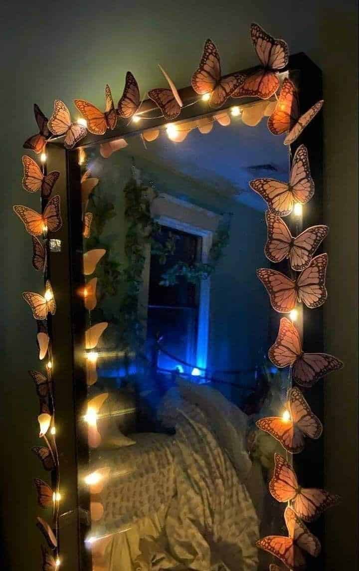 Espejo con el marco decorado con mariposas y luces