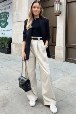 Camisa negra con pantalón crema ancho y tenis