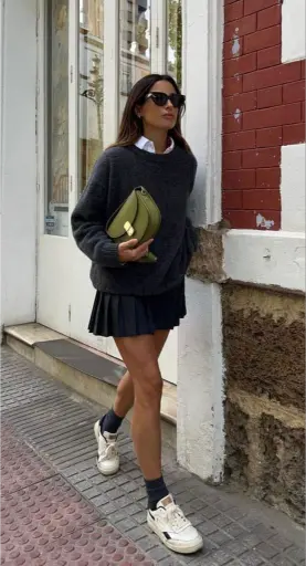 Jersey negro con falda plisada corta y calcetines