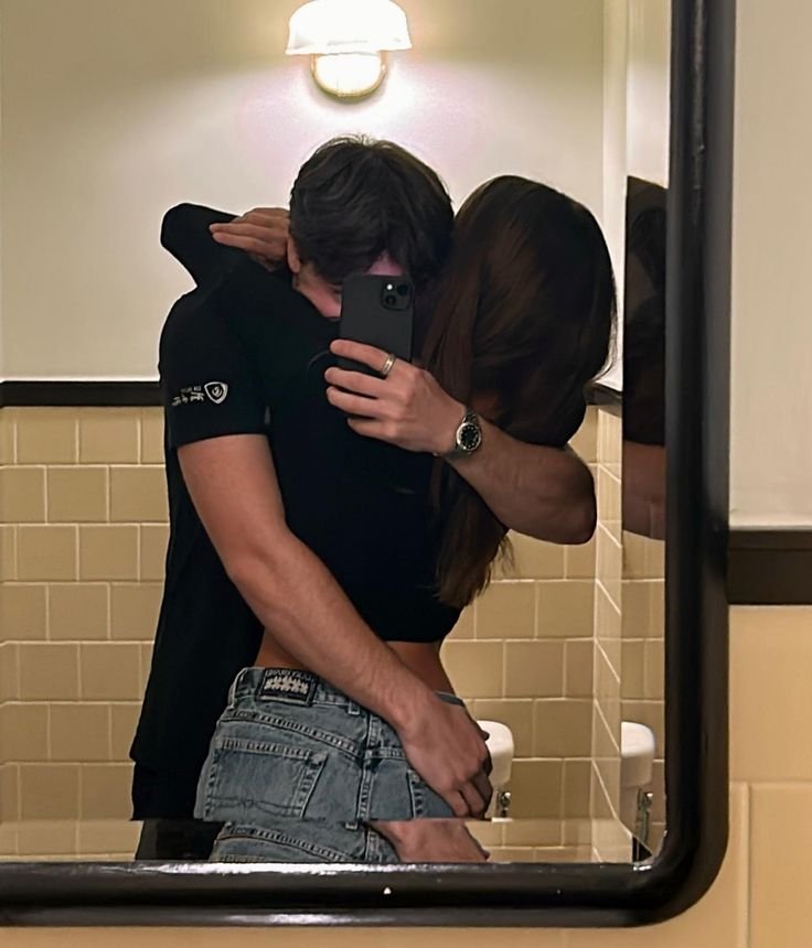 Selfie de pareja abrazada en el espejo del baño