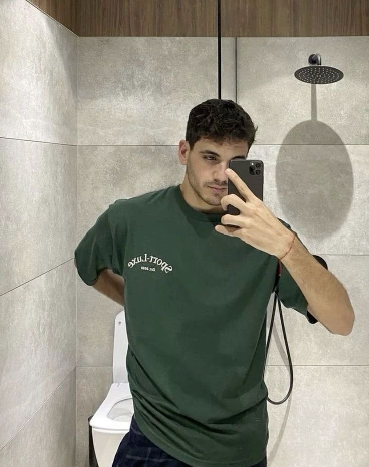 Selfie en el espejo del baño con camiseta verde