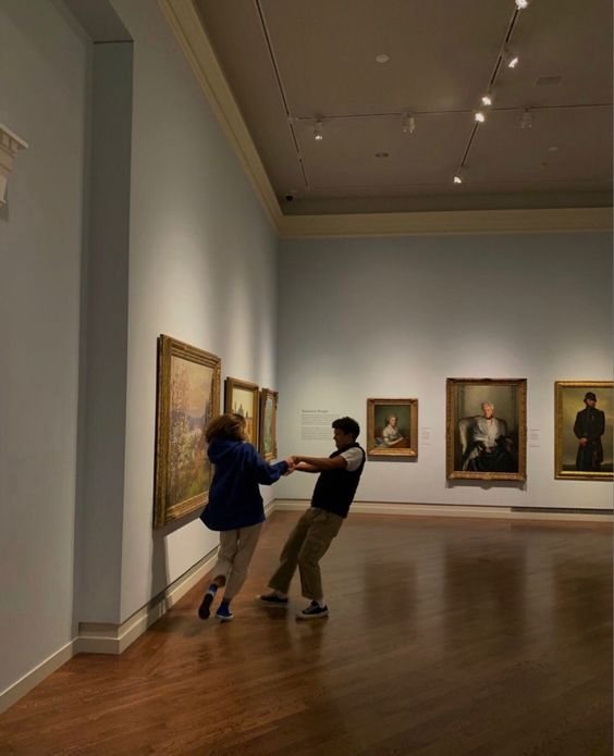 Pareja de espaldas mirando cuadros en un museo