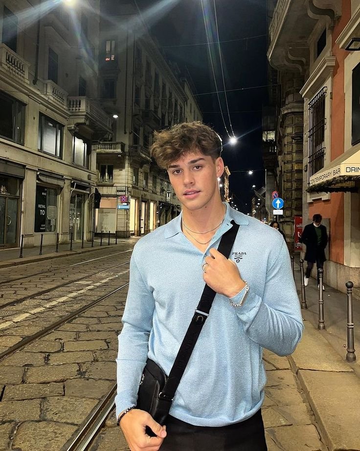 Chico de pie en una calle de noche