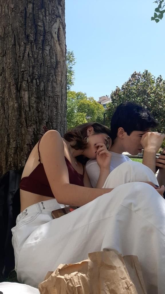Pareja sentada en el suelo bajo un árbol
