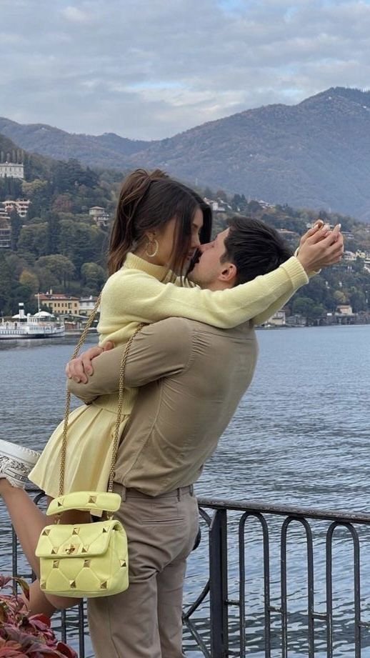 Selfie de pareja junto a un lago con montañas de fondo