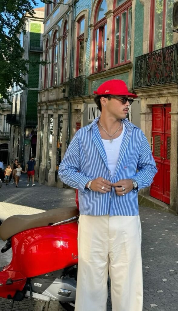 Camisa de rayas azul con pantalón crema y gorra roja