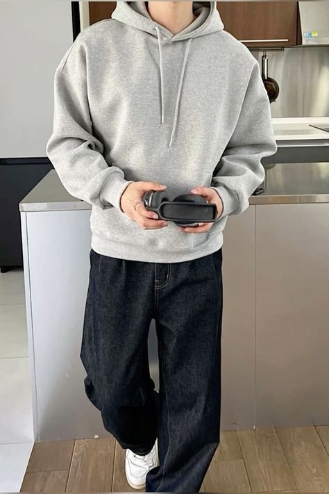Sudadera gris con capucha y jeans oscuros anchos