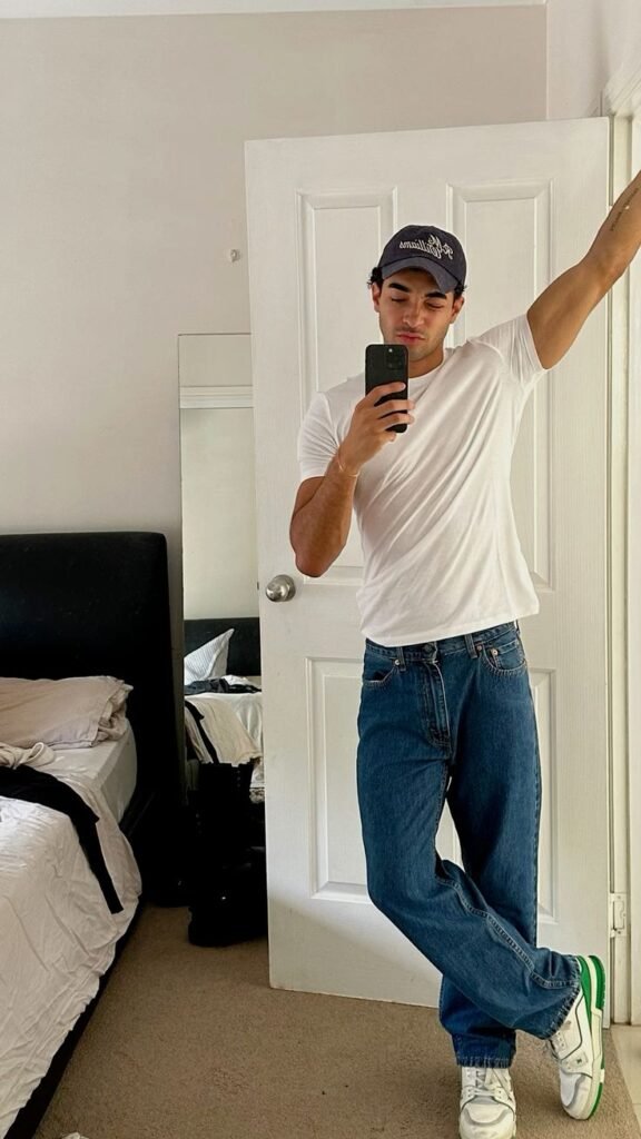 Camiseta blanca con jeans azules y gorra