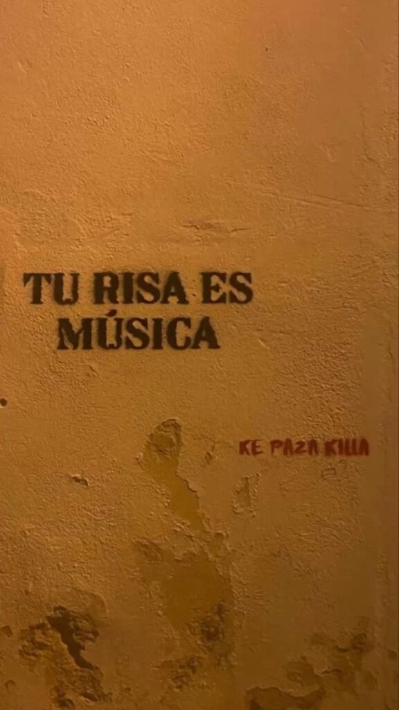 Pintada en una pared naranja: tu risa es música