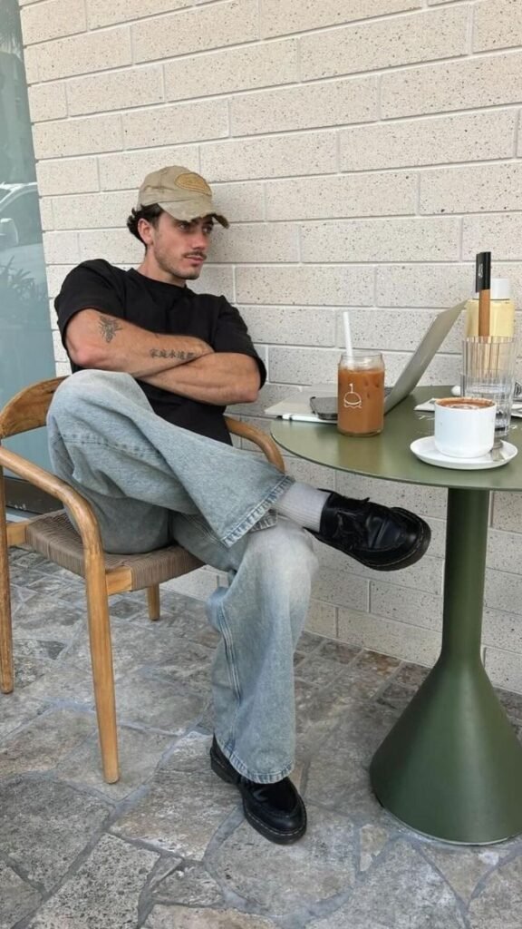 Camiseta negra con pantalón beige ancho y gorra