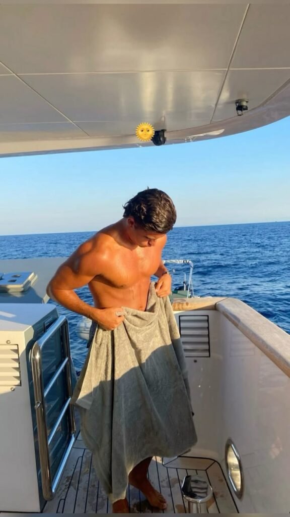 Chico de pie en un barco con toalla