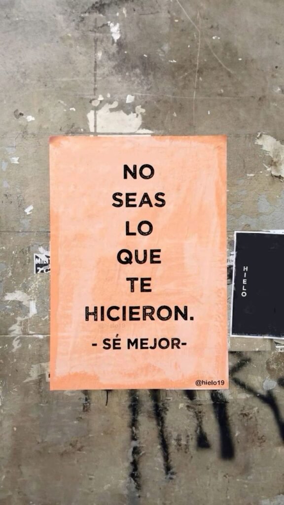 Cartel naranja en una pared: no seas lo que te hicieron, sé mejor