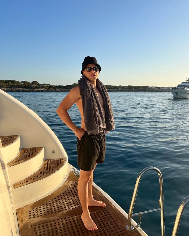 Chico de pie en un barco con toalla al hombro
