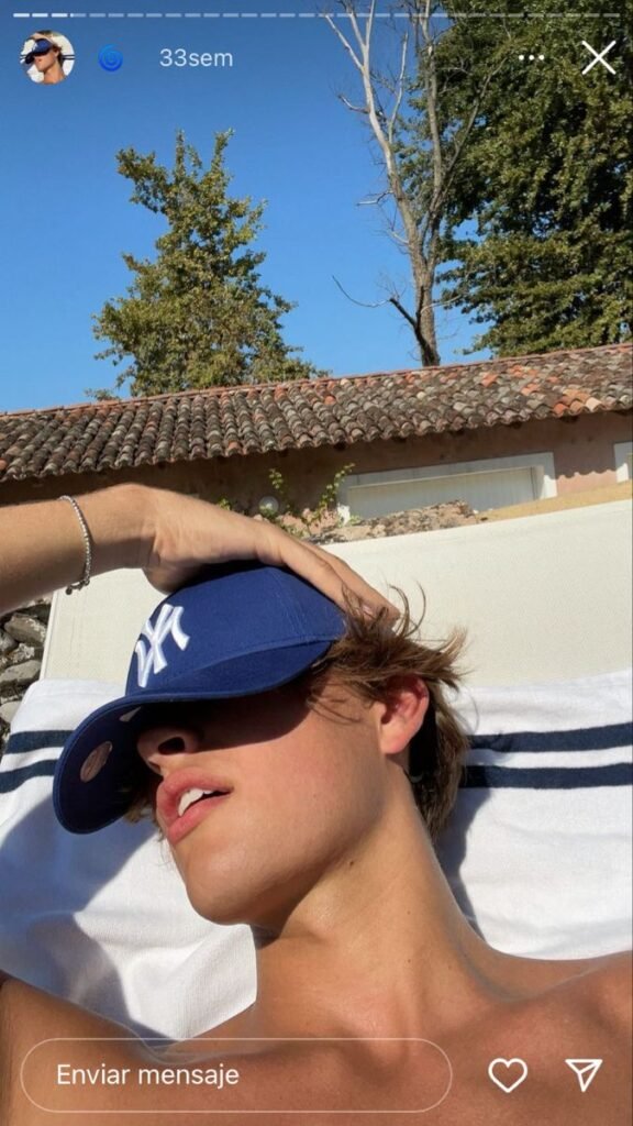 Chico tumbado con una gorra tapándole la cara