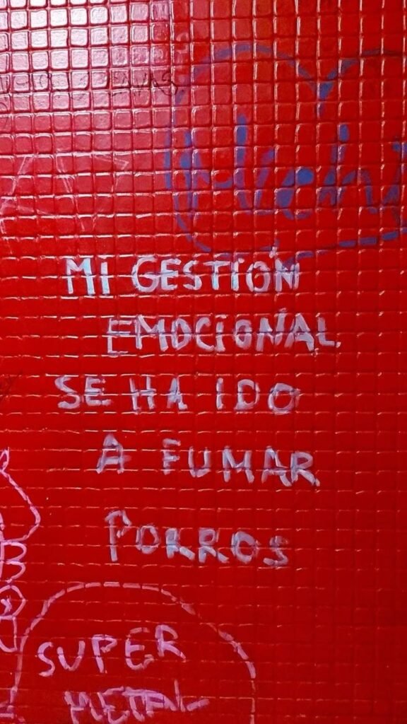 Pintada en una pared roja con una frase con humor
