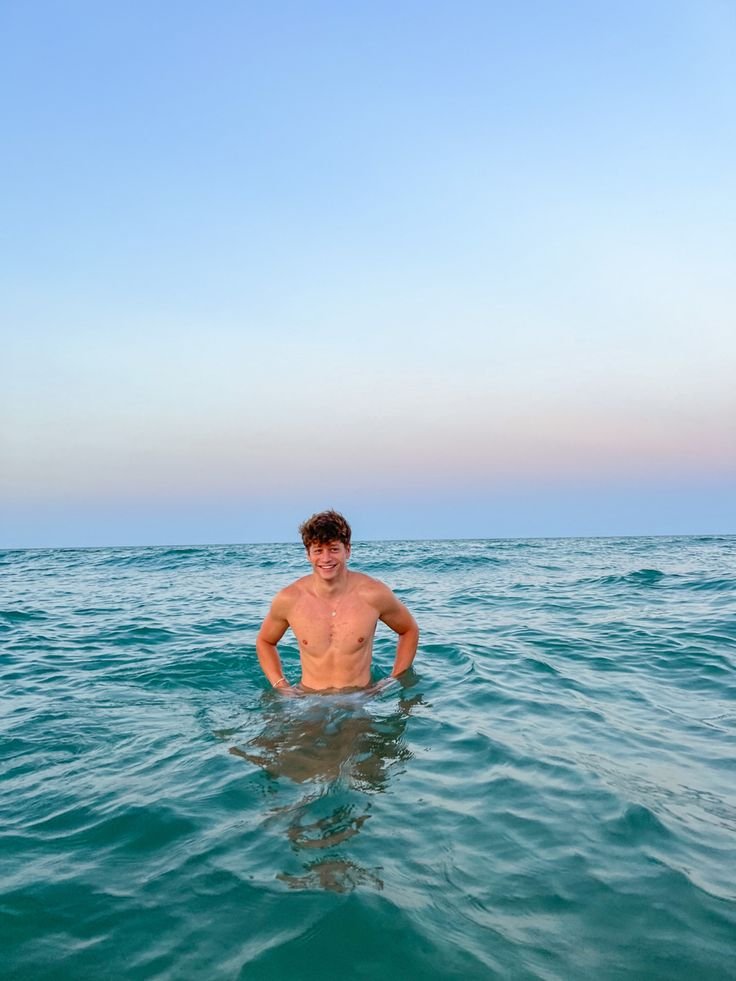 Chico de pie dentro del mar con el agua por la cintura