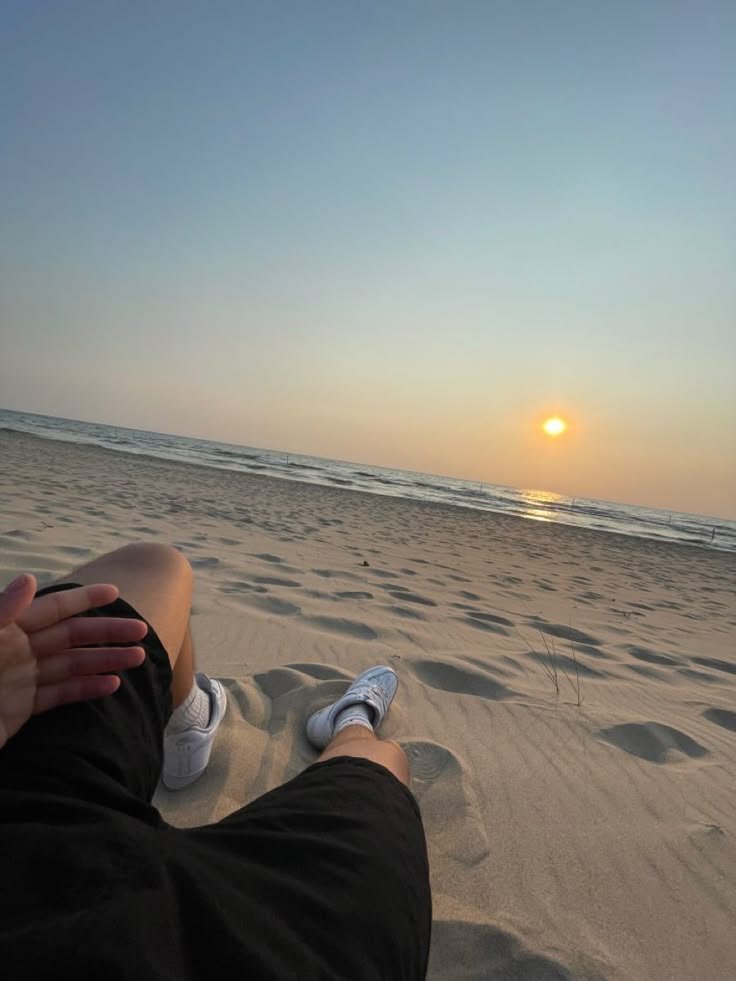 Pies apoyados en la arena al atardecer