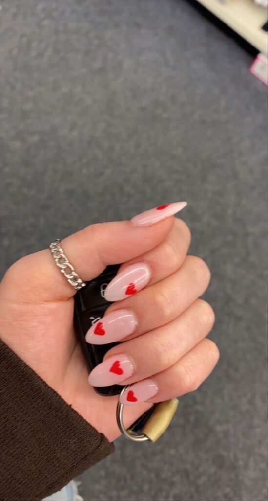 Uñas nude con corazones rojos pequeños