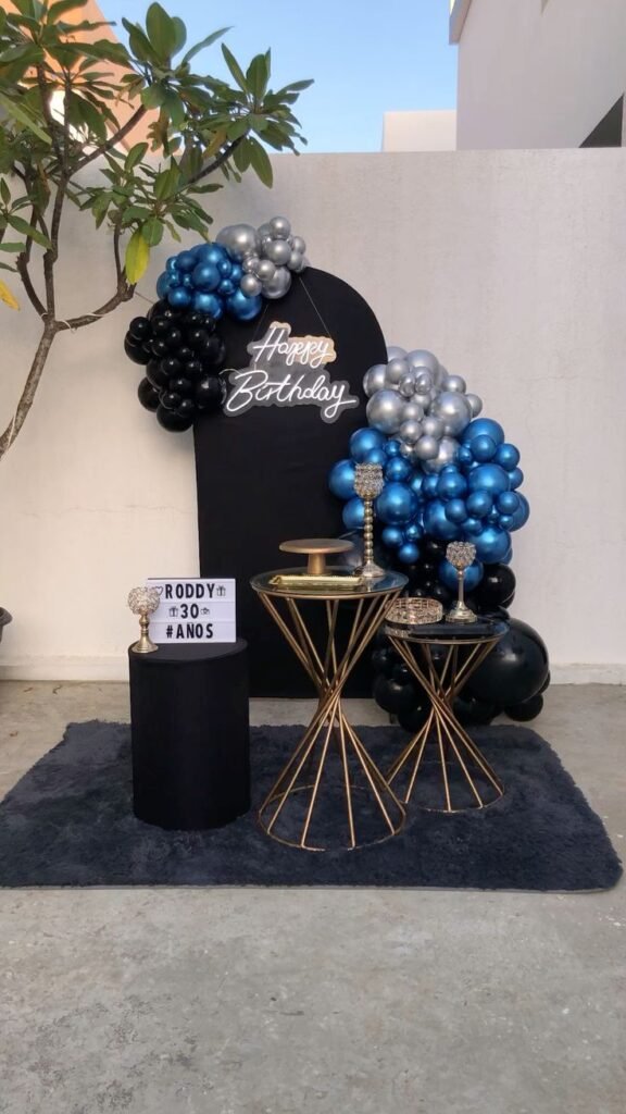 Panel negro con globos azules y plateados