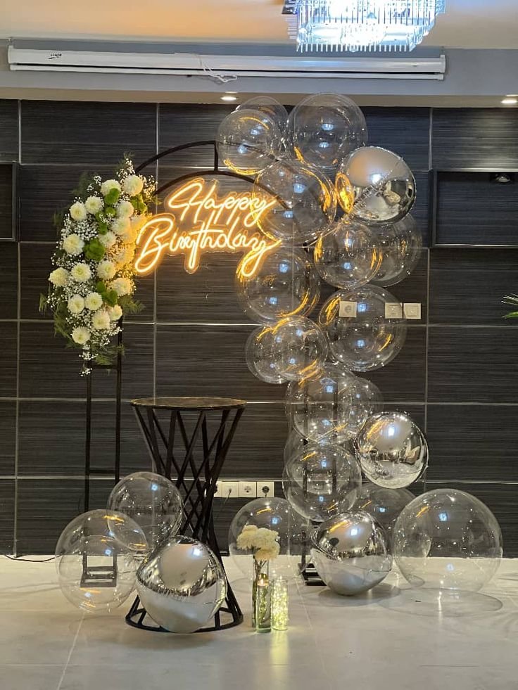 Arco de globos transparentes con neón de Happy Birthday