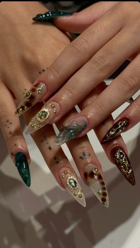 Uñas largas oscuras con pedrería y dibujos