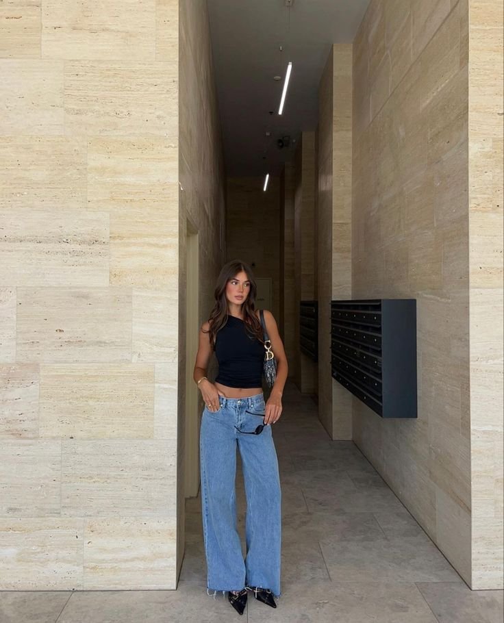 Top negro corto con jeans claros anchos