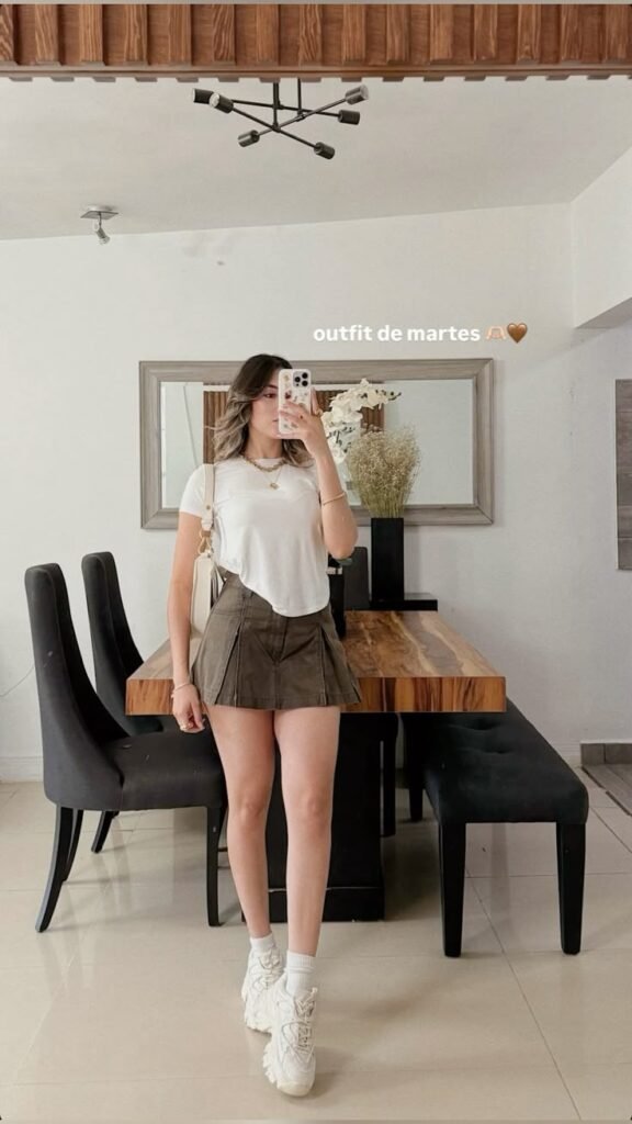 Camiseta crema con shorts marrones y tenis blancos