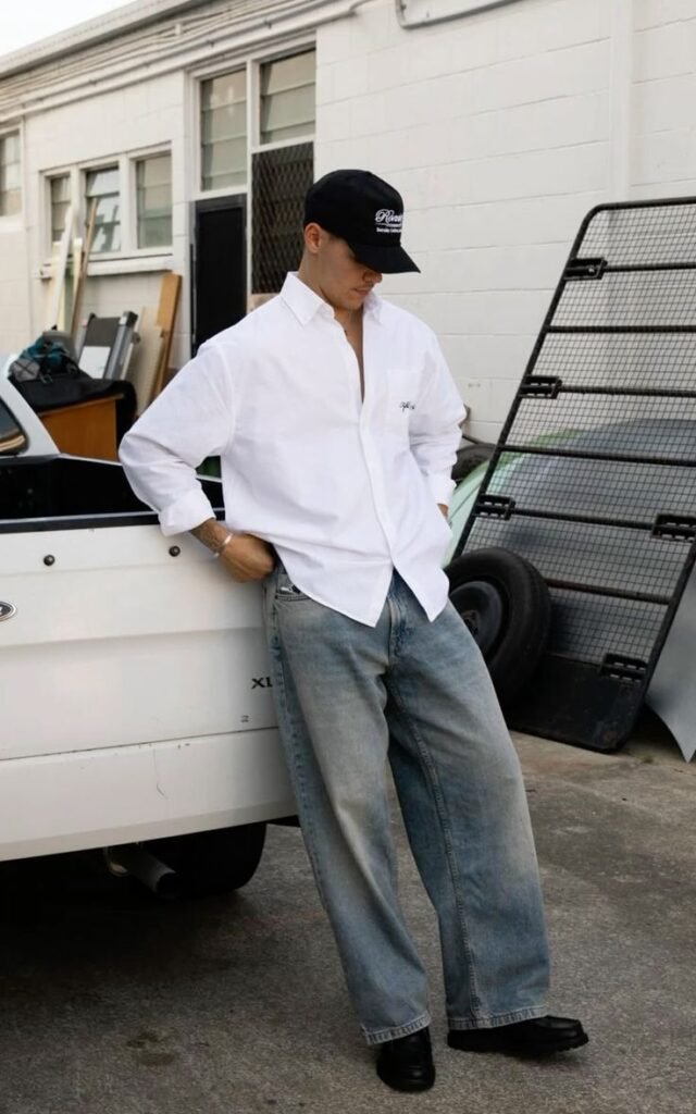 Camisa blanca con jeans anchos grises y gorra