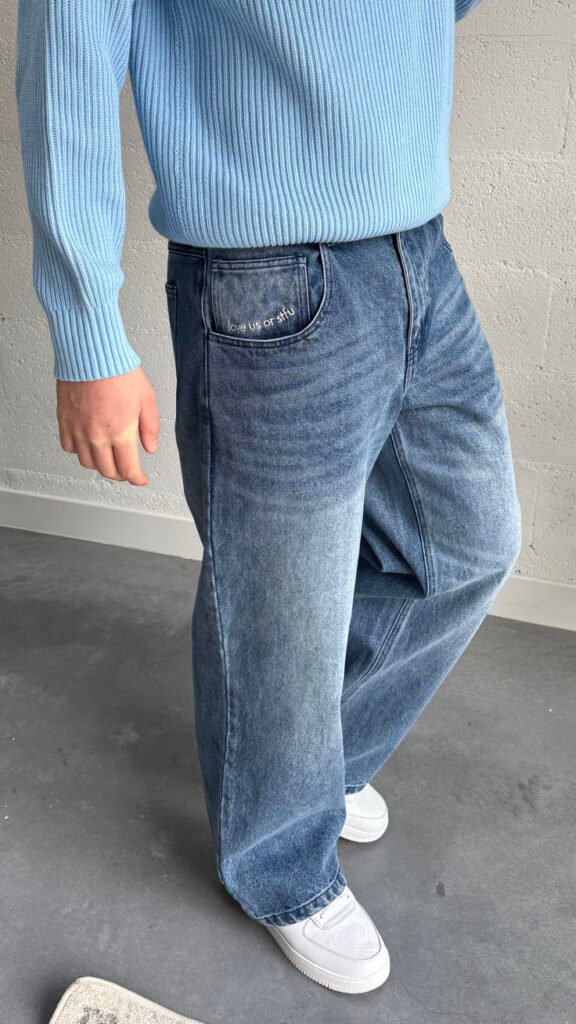 Jersey azul claro con jeans anchos grises