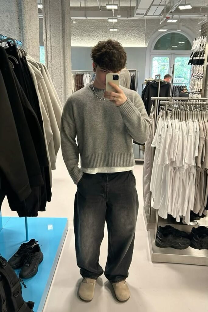 Jersey gris con jeans anchos oscuros