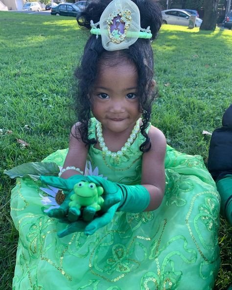 Niña disfrazada de princesa con vestido verde y rana