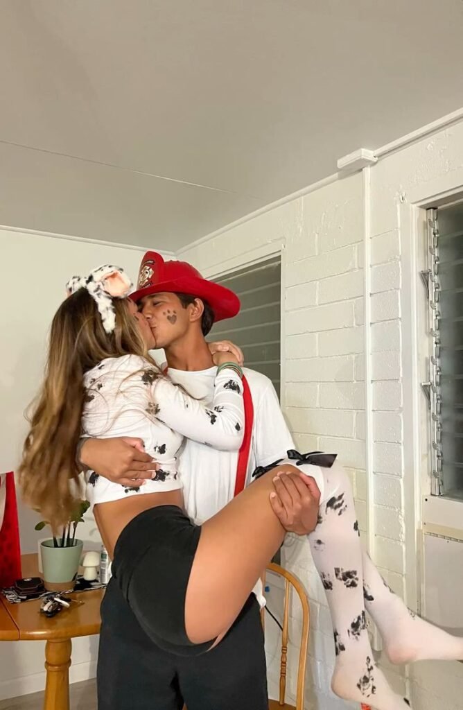 Pareja disfrazada de bombero y dálmata con perro