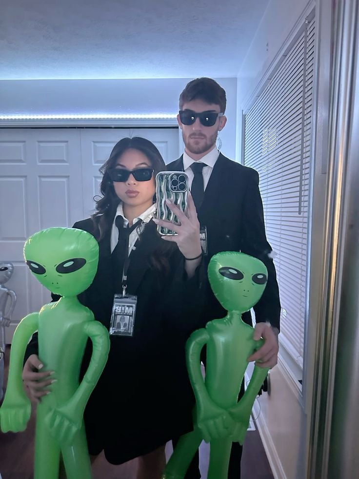 Pareja disfrazada de agentes con alienígenas hinchables