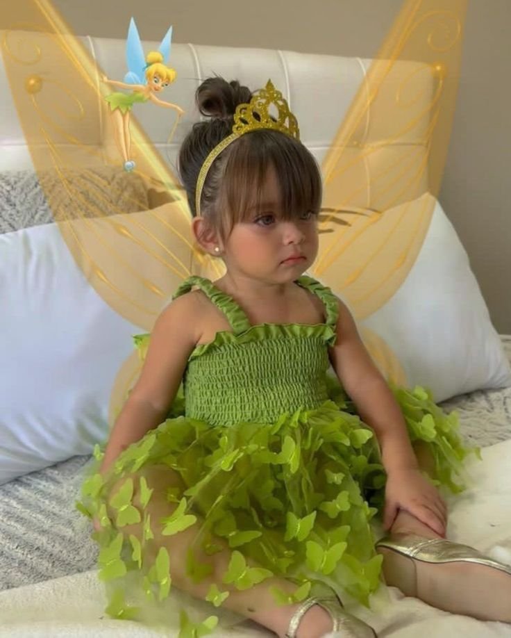 Niña disfrazada de hada con vestido verde y alas