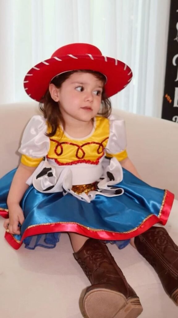 Niña disfrazada de vaquera con sombrero rojo