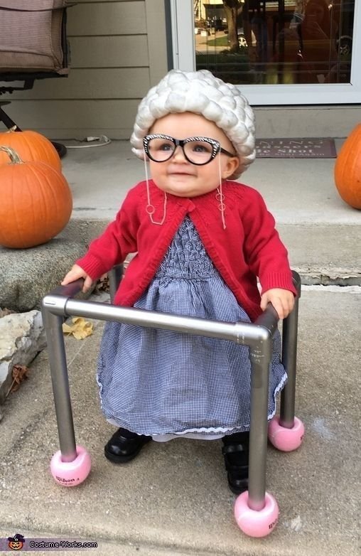 Niña disfrazada de abuelita con andador y peluca blanca