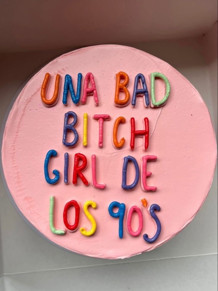 Tarta rosa con un mensaje escrito en glaseado de colores