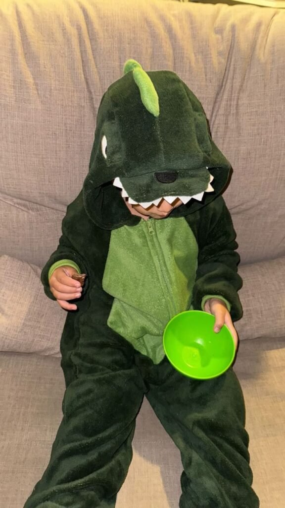 Niño disfrazado de dinosaurio verde