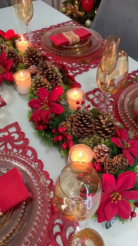 Mesa puesta en rojo con piñas, velas y flor de pascua
