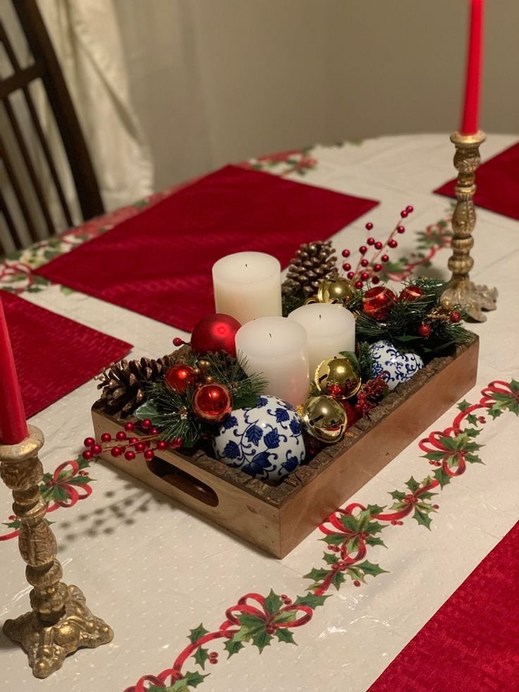 Bandeja de madera con velas, bolas y camino de mesa rojo