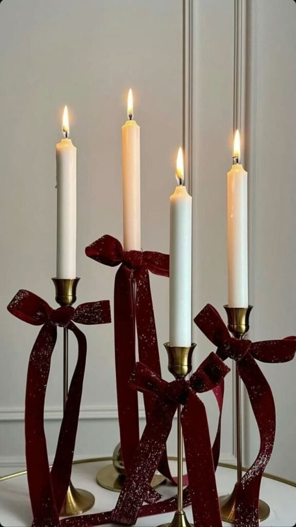 Candelabro con velas blancas y lazos de terciopelo burdeos