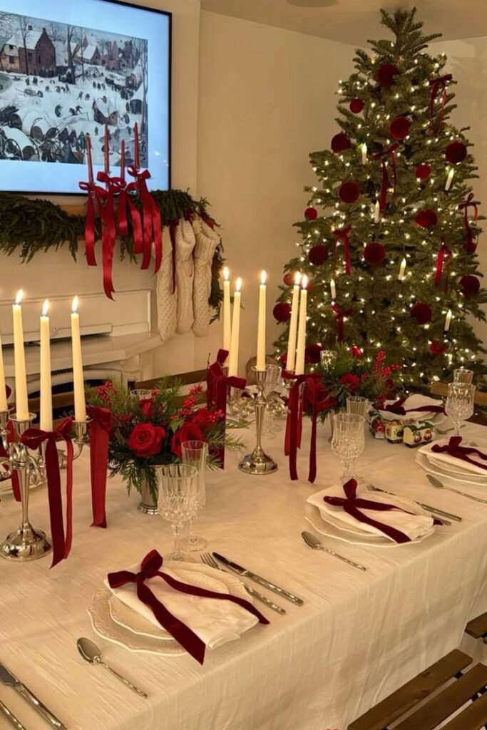 Mesa puesta en rojo y blanco con velas y árbol de fondo